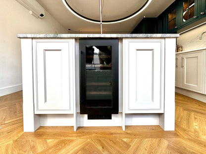 Helglasad vinkyl från Dunavox med svart handtag i vit köksö med parkettgolv. 