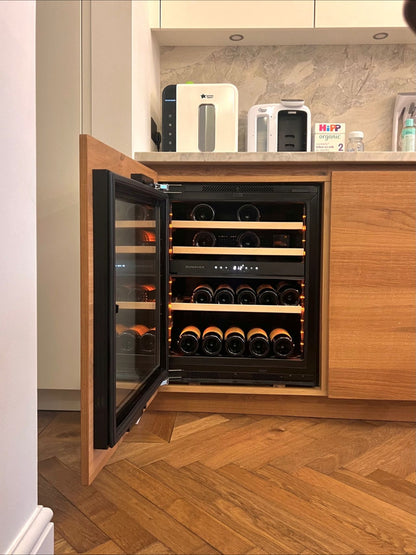 Integrerbar Dunavox Nordic vinkyl monterad i köksskåp med öppen dörr och vinflaskor på trähyllor